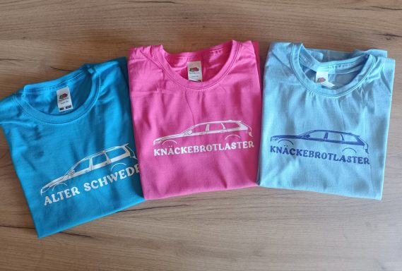 Drei T-Shirts in Türkis, Pink und Hellblau mit einem Auto-Design und dem Schriftzug.