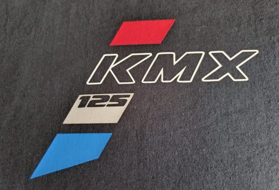 Logo "KMX 125" mit roten und blauen geometrischen Formen auf schwarzem Hintergrund.