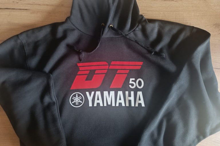 Schwarze Kapuzenjacke mit rotem DT 50 Yamaha Logo auf der Vorderseite.