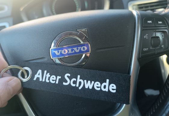 Volvo-Logo auf einem Lenkrad mit einem Schlüsselanhänger mit der Aufschrift "Alter Schwede".