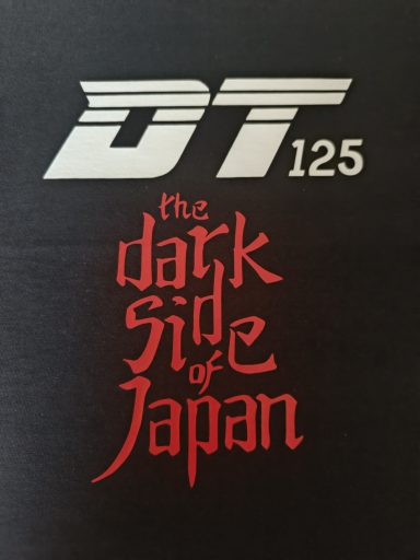 Auf schwarzem Hintergrund steht "DT 125" und darunter "the dark side of Japan" in roter Schrift.