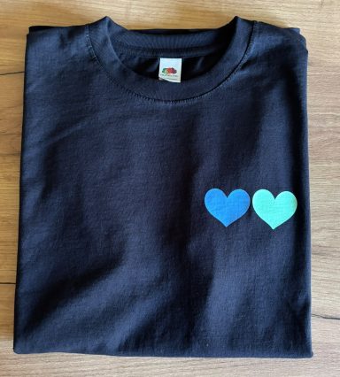 Schwarzes T-Shirt mit zwei Herzen in Blau und Türkis auf der Vorderseite.