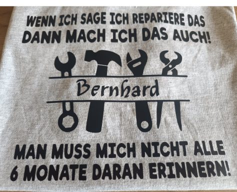 Graues T-Shirt mit Werkzeugmotiven und dem Text: "Wenn ich sage ich repariere das, dann mach ich das auch!"